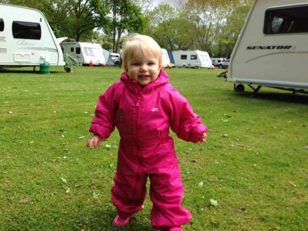 Toddler walking on caravan rally field in waterproof