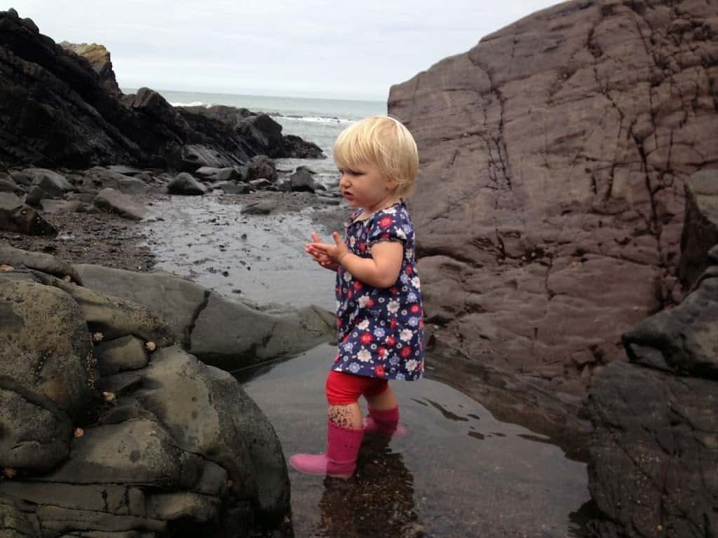 Tin Box Tot standing in a rock pool at Hartland Quay