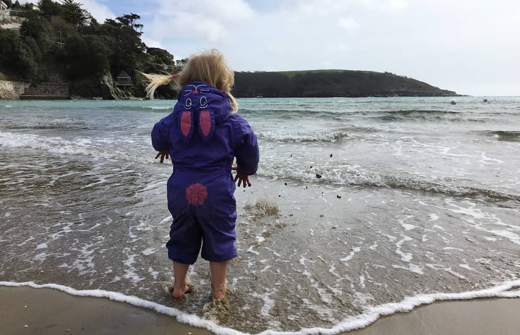 Tin Box Tot dipping her toes in the sea at North Sands Salcombe Devon
