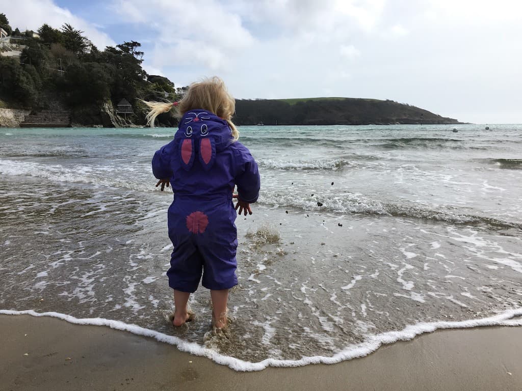 Tin Box Tot dipping her toes in the sea at North Sands Salcombe Devon