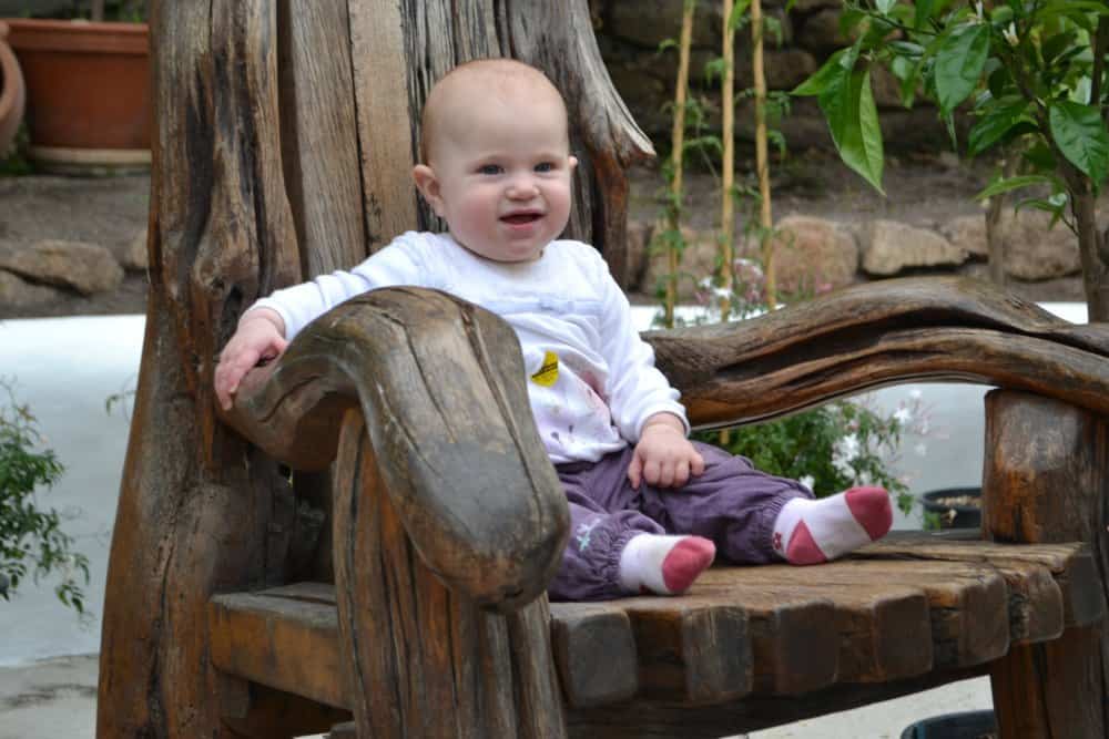Tin Box Baby sitting on the story teller's chair in the Mediterranean Biome - The Eden Project: a family day out in Cornwall 