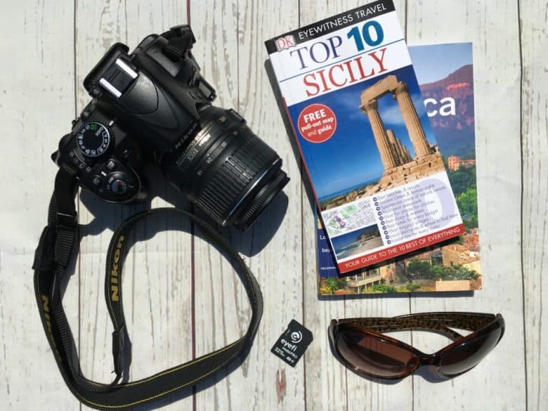 DSLR camera, Eyefi Mobi Pro SD card, travel guides and sunglasses