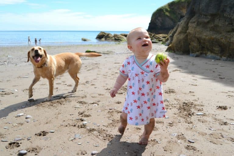 Tin Box Baby playing with Tin Box Dog while wearing her Rockin' Baby outfit - kids summer holiday clothes