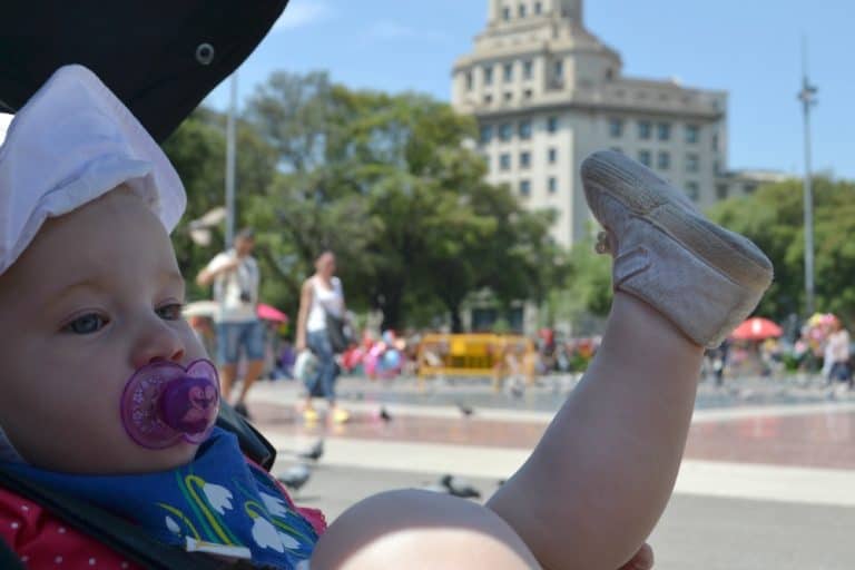 Tin Box Baby watching pigeons in Placa Catalonia - Barcelona with a buggy