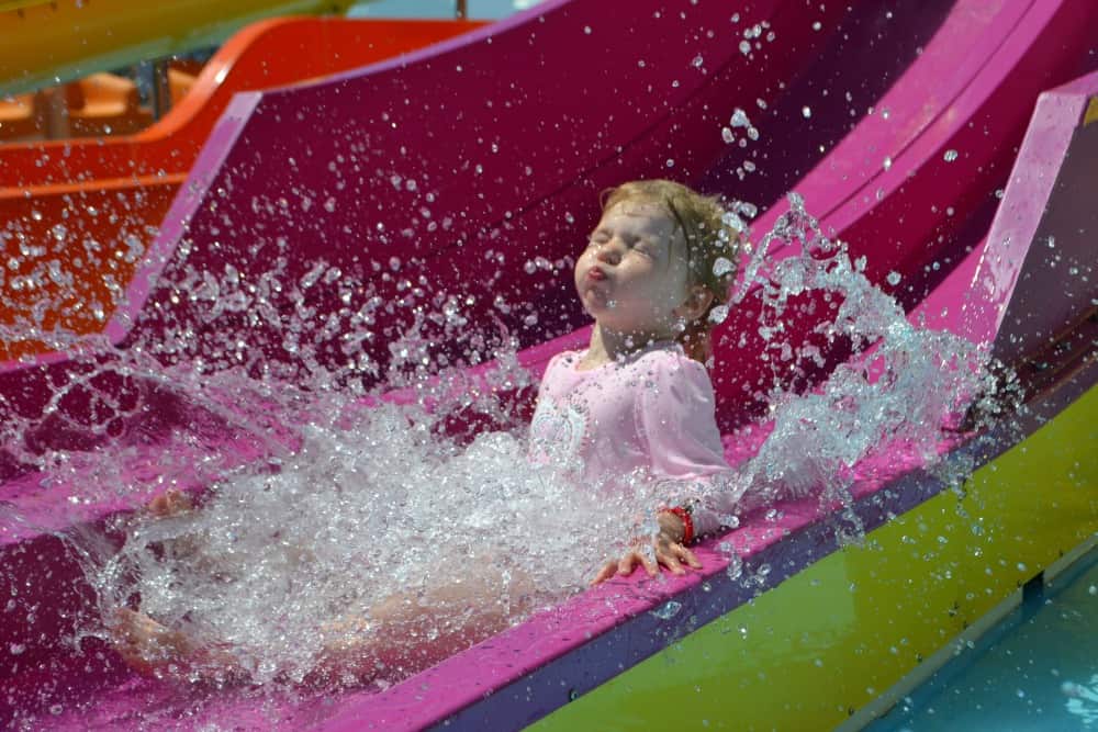 Tin Box Tot splashed at the bottom of a water slide - safe summer fun