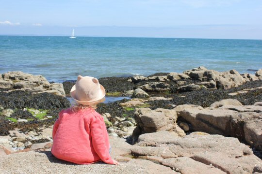 Minnie from Mummytravels sat on Shoalstone Beach - great Devon family days out