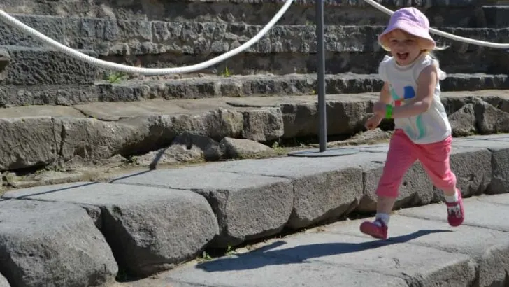 Tin Box Tot running around an amphitheatre in Pompeii - How not to see Pompeii with kids