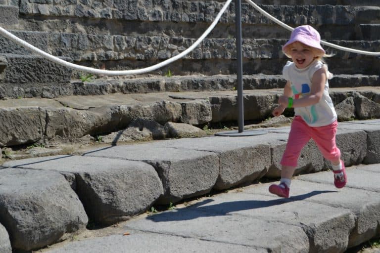 Tin Box Tot running around an amphitheatre in Pompeii - How not to see Pompeii with kids