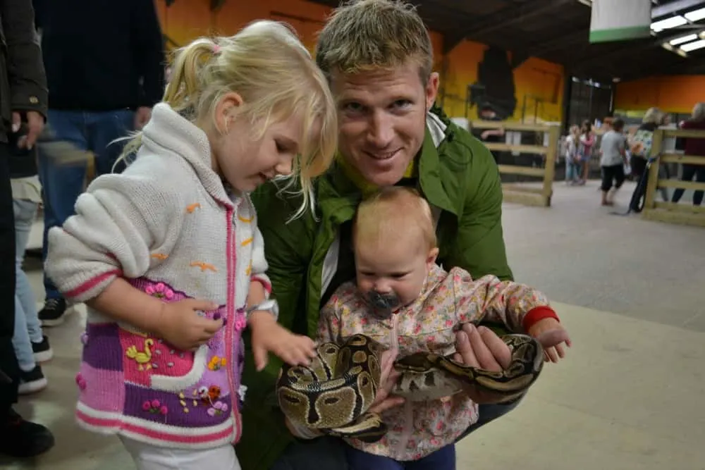 Tin Box girls holding a snake in the Animal Kingdom at Crealy Adventure Park - glamping at Crealy
