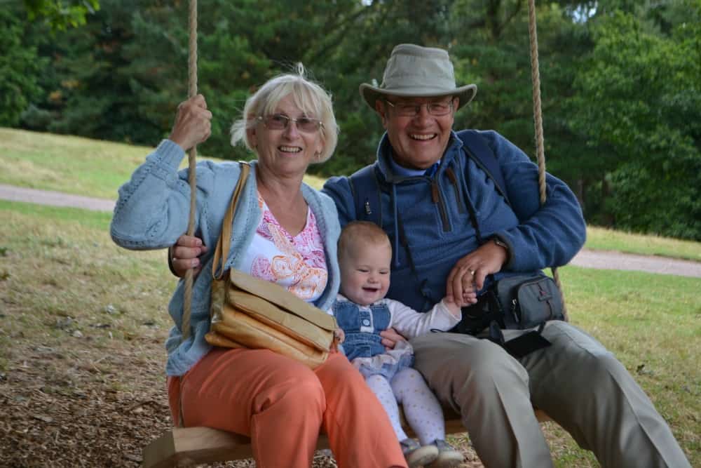 Tin Box Baby and grandparents on a tree swing - visiting Killerton National Trust with children