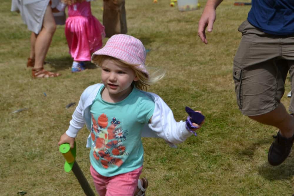 Tin Box Tot running with a bag of gold at Powderham Castle