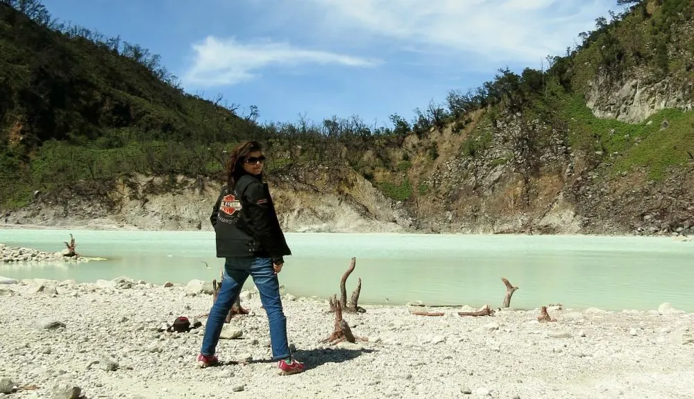 Jo from Wander with Jo standing in front of a sulphur lake in Indonesia