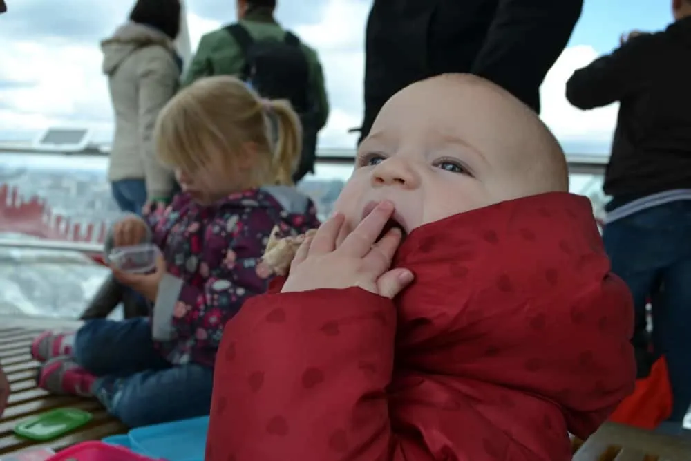 Tin Box Baby snacking on the London Eye - Sanity saving tips for doing London with a toddler or baby