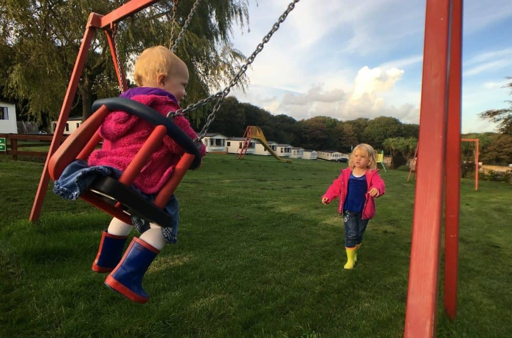 Tin Box girls playing on the swings at Trevella Holiday Park, Cornwall