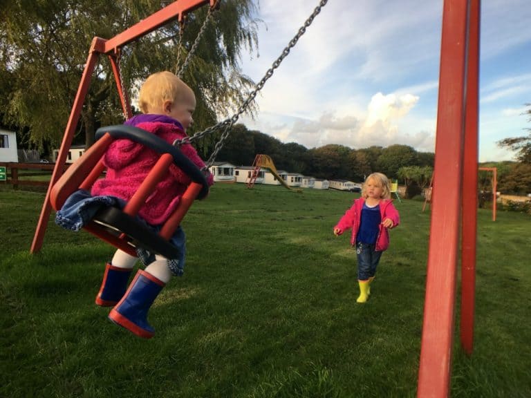 Tin Box girls playing on the swings at Trevella Holiday Park, Cornwall