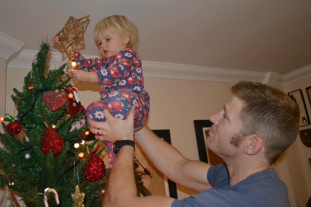 Tin Box Tot and Mr Tin Box decorating Christmas tree - what matters most at Christmas with Holiday Inn Express