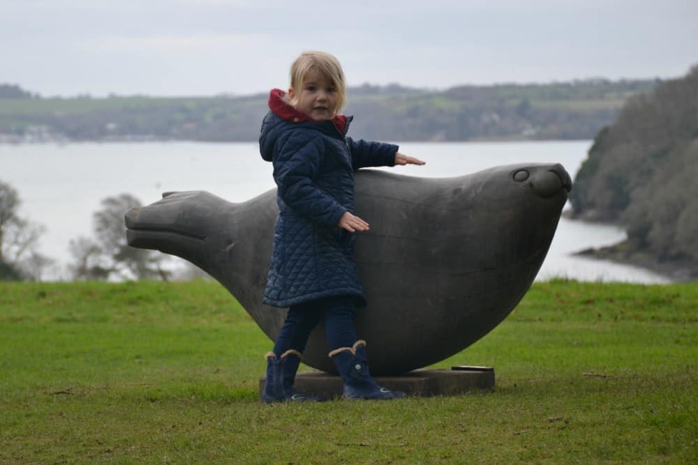 Tin Box Tot looking at a seal sculpture overlooking the River Fal - Trelissick National Trust