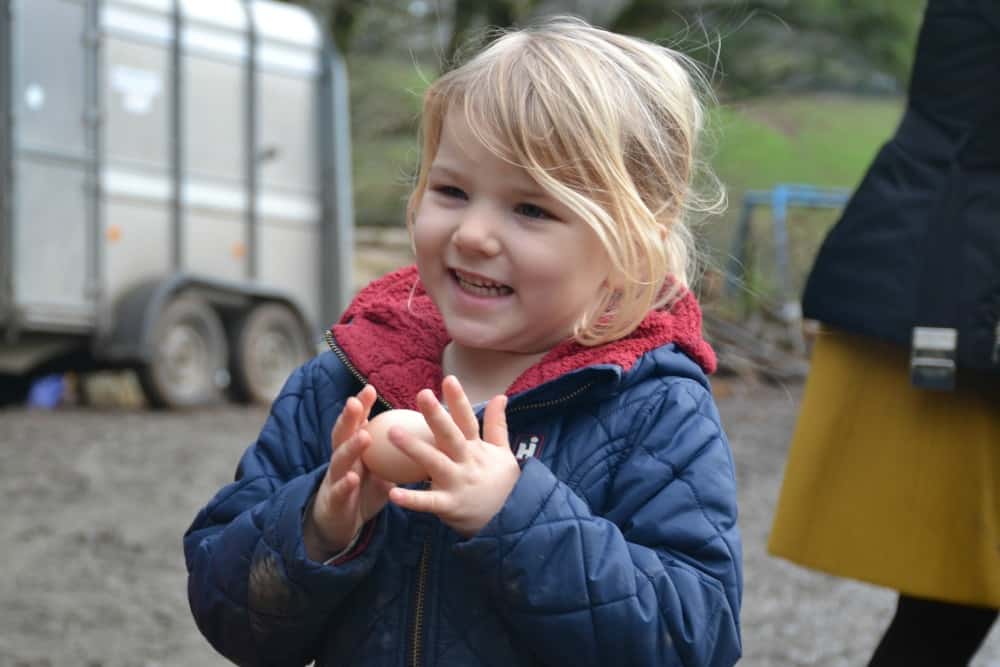 Tin Box Tot holding egg - A perfect winter holiday with children at Bosinver, Cornwall