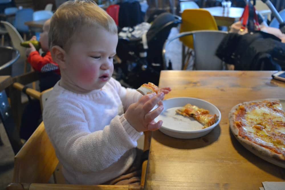 Tin Box Baby eating pizza at ODE&Co at Coast View Holiday Park