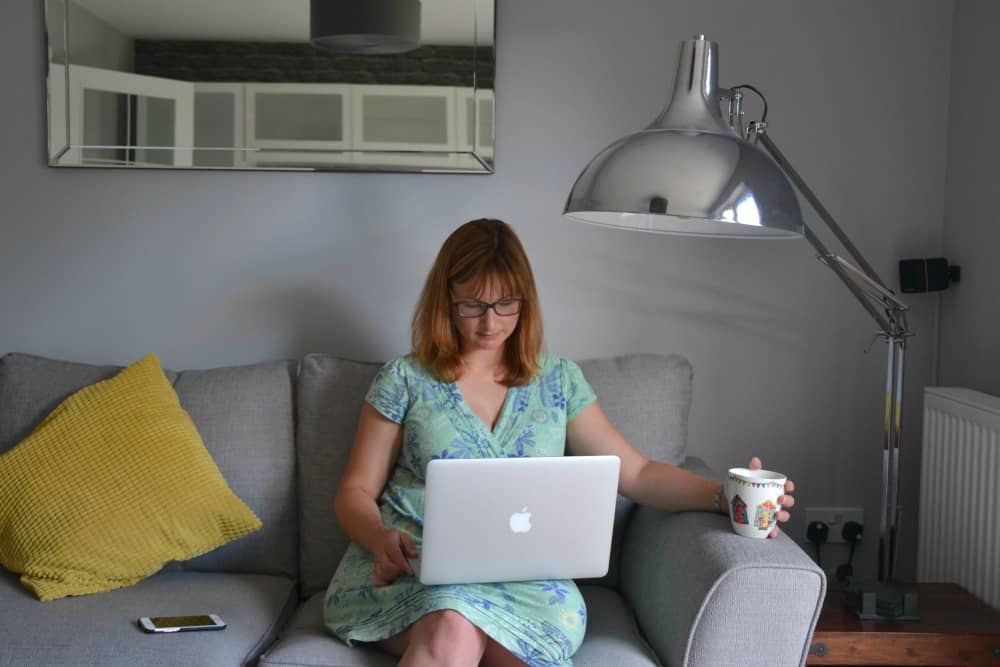Tin Box Traveller learning French online sitting with laptop computer on lap