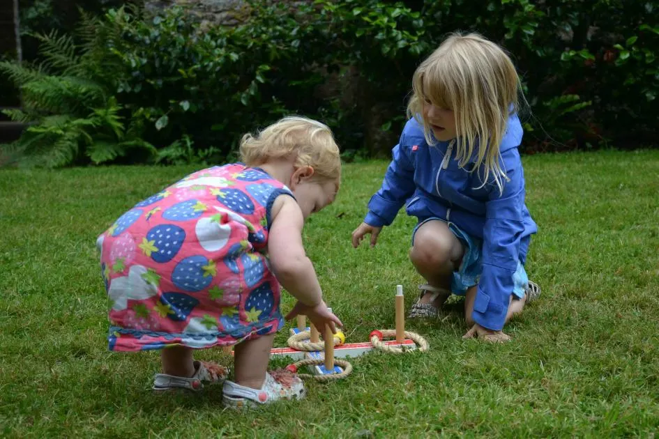 Tin Box girls play coins at in courtyard at Compton Castle Tudor Days