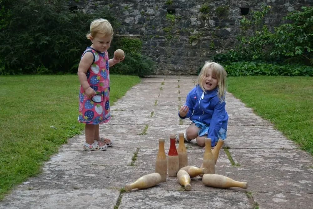 Tin Box girls playing skittle in courtyard at Compton Castle Tudor Days