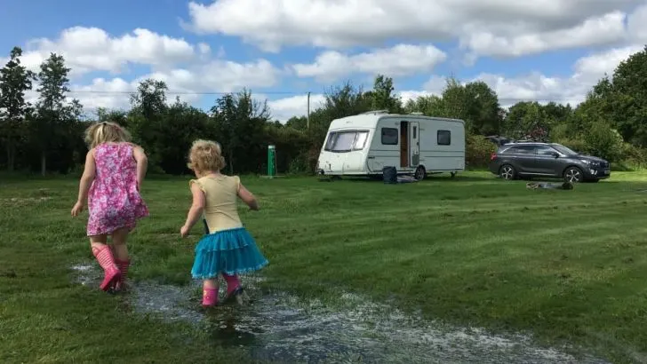 Tin Box girls paddling in puddle at Scotts Haven - A caravan holiday in England - our family road trip itinerary