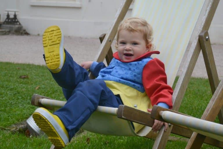 Tin Box Baby kicking in deck chair wearing Kidunk tough clothes for toddlers