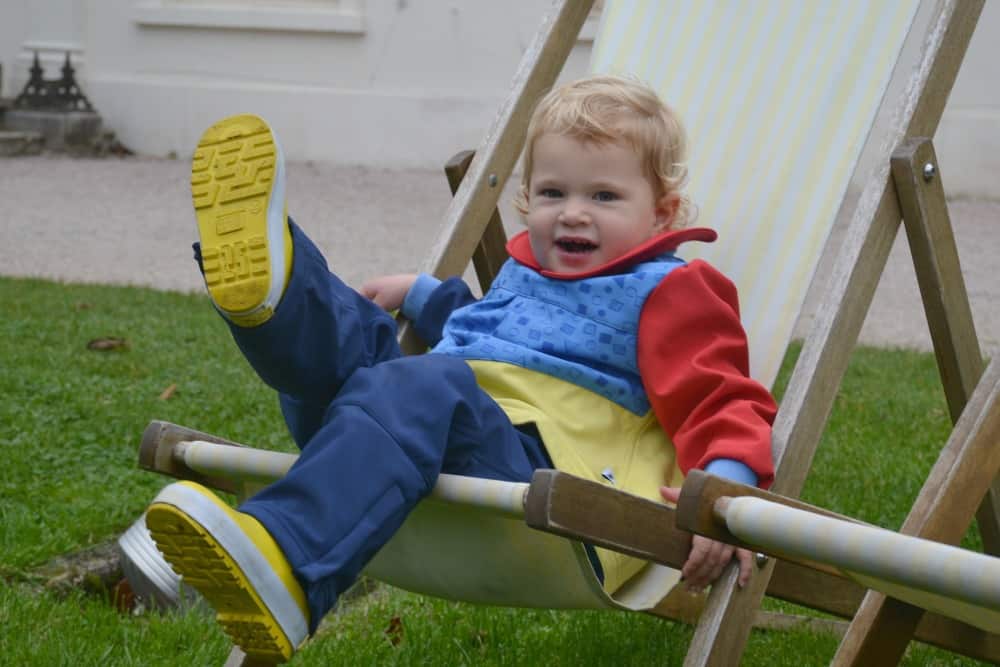 Tin Box Baby kicking in deck chair wearing Kidunk tough clothes for toddlers