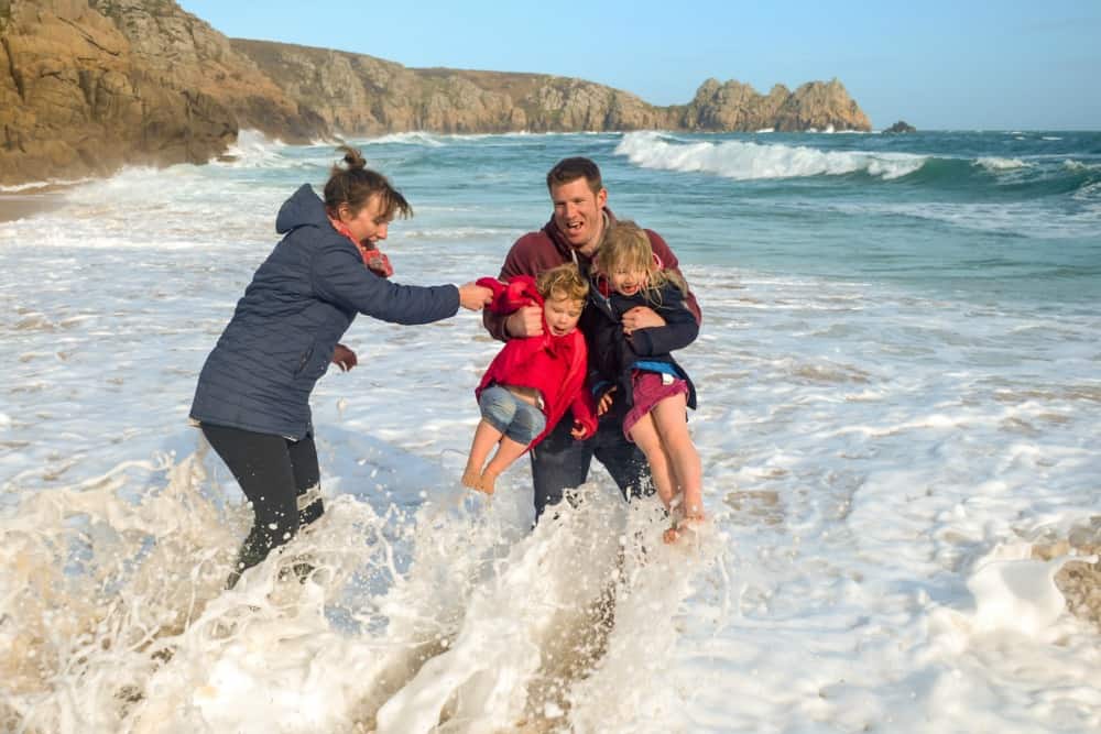 Tin Box family caught in wave on Portcurno Beach, Cornwall - family travel tips