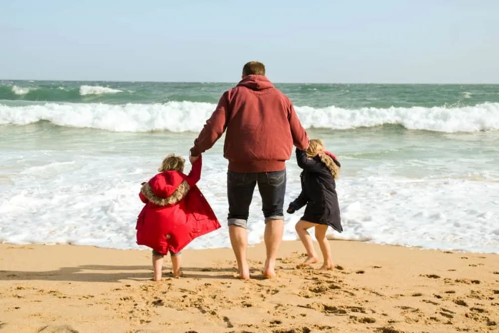 Tin Box family jumping waves on Portcurno Beach, Cornwall