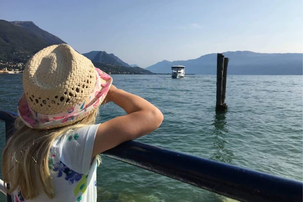 Tot looking at boat on Lake Garda