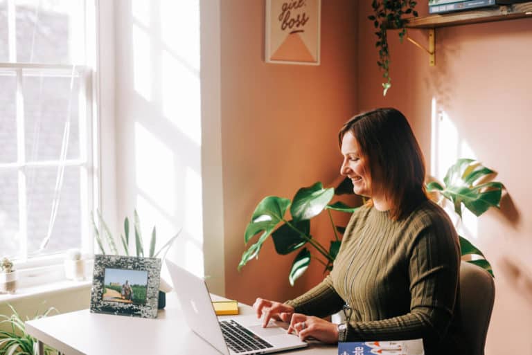 Claire on laptop at desk in pretty office space