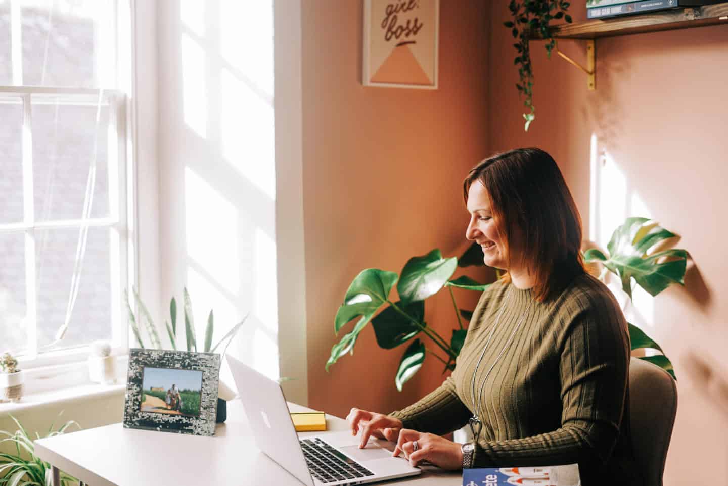 Claire on laptop at desk in pretty office space