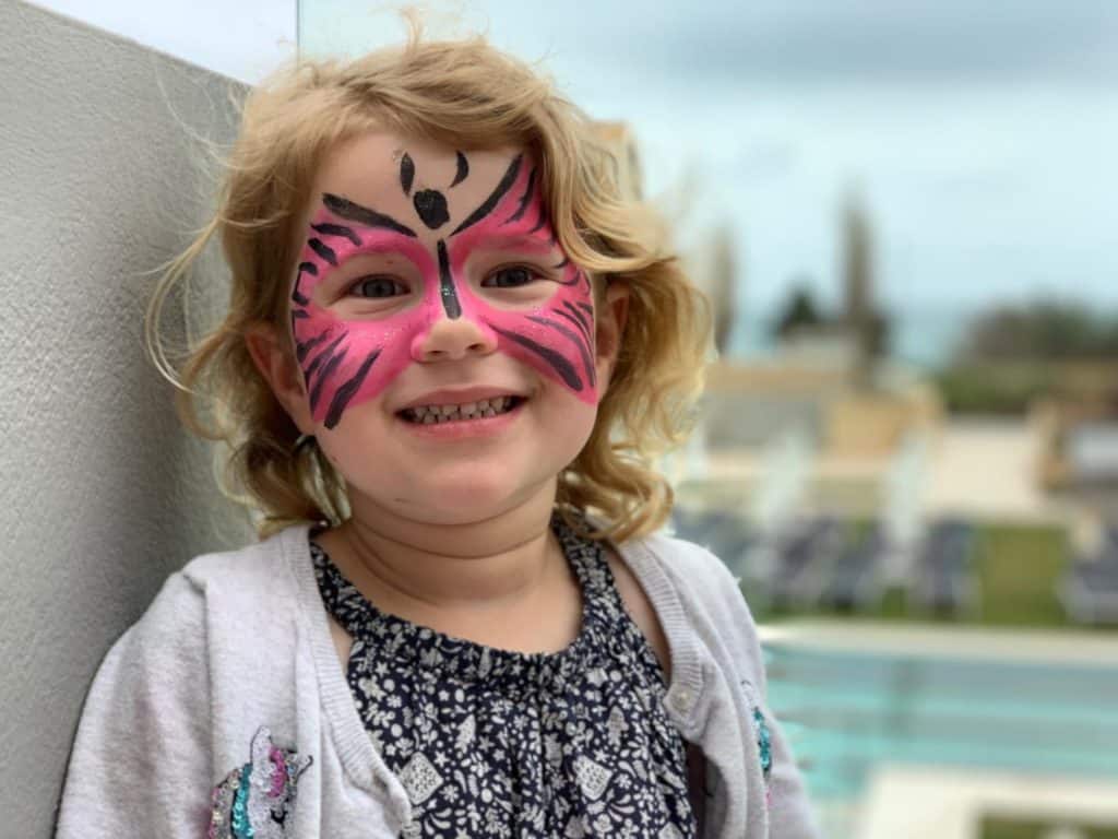 Baby with face paint from Kiani Kids Club at Kiani Beach Hotel in Crete