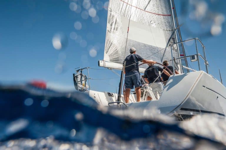 Aft of sailing boat with skipper from underwater view