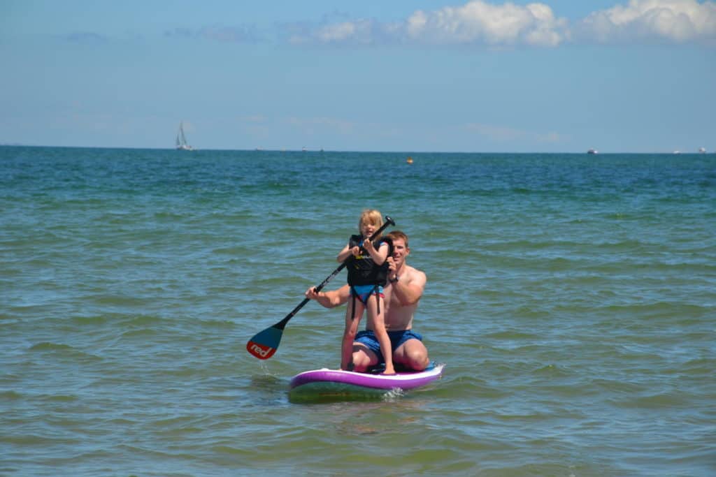 Kid standing on a paddle board