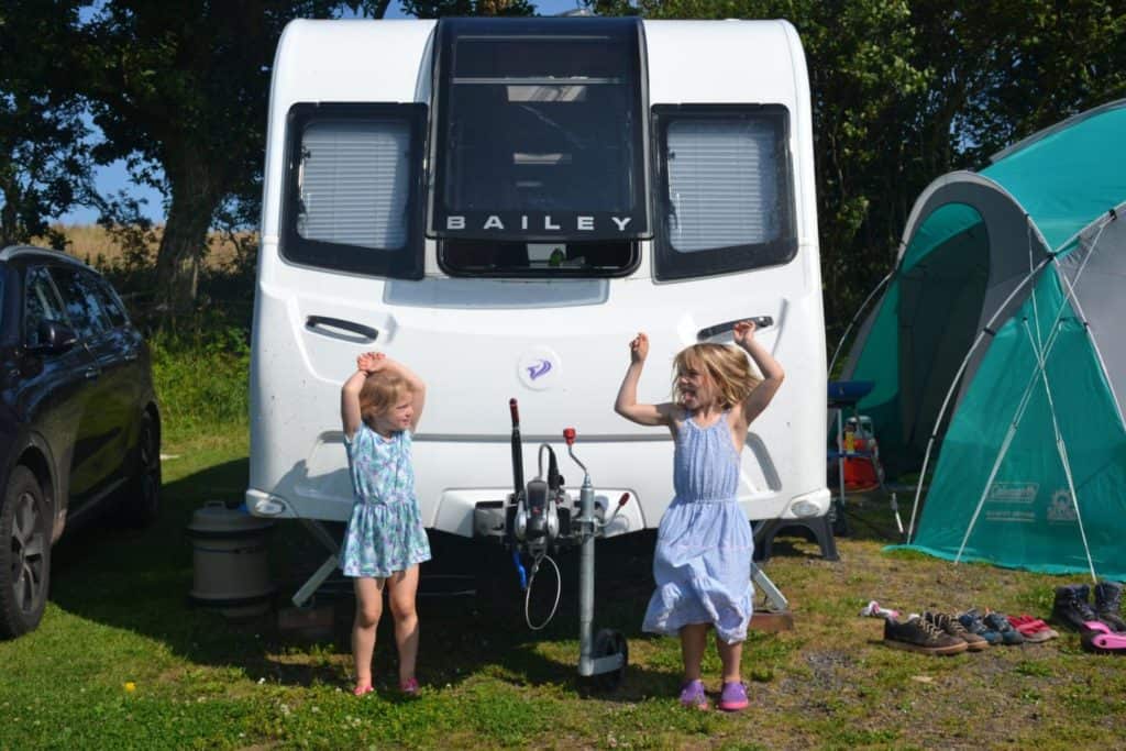 Kids jumping in front of caravan