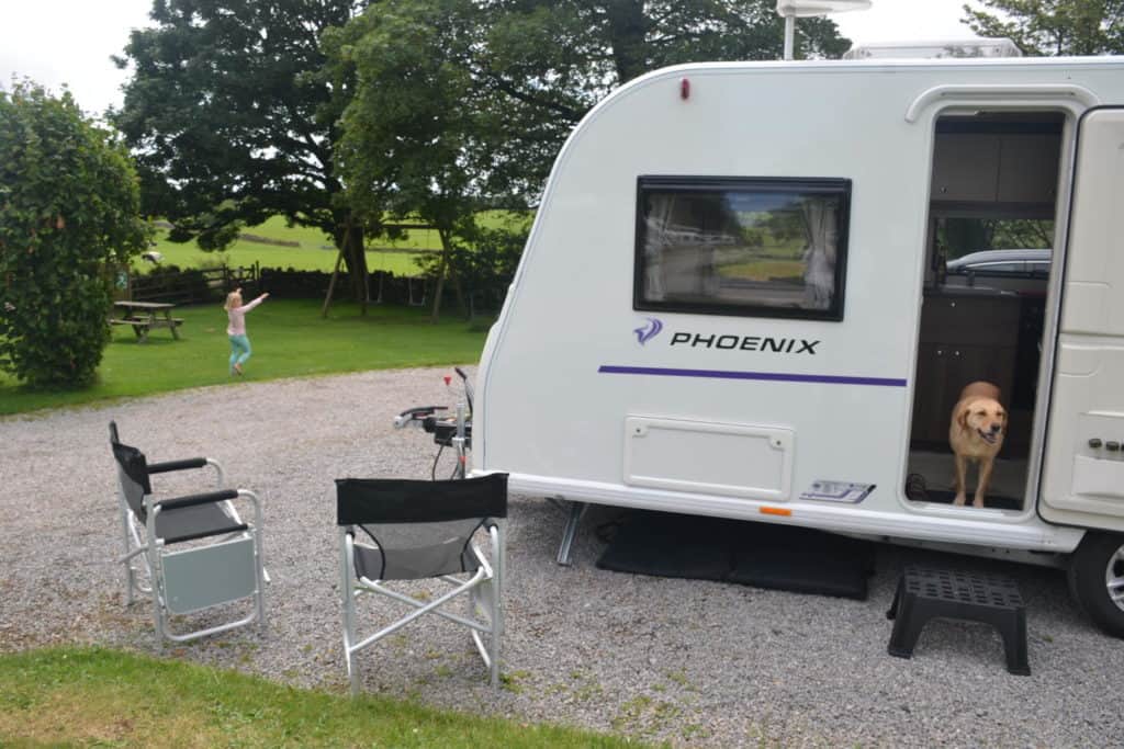 Caravan pitched next to playground at Cedar Mendip Heighs Camping and Caravan Club site in Somerset