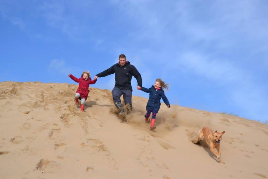 Running down sand dune on Crantock Beach in Cornwall