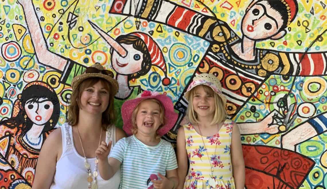 Family standing in front of Pinocchio mural