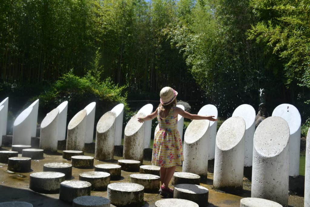Tot standing among shark teeth in sculpture at the Pinocchio Park in Tuscany