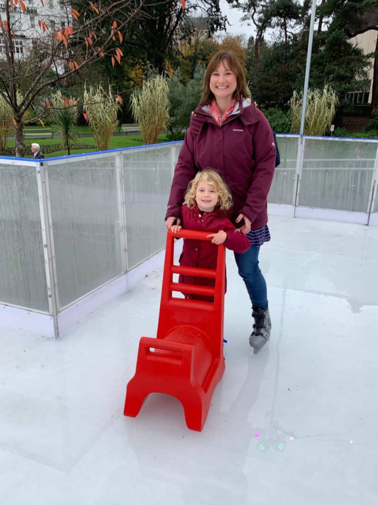 Mum and daughter ice skating with skating aid