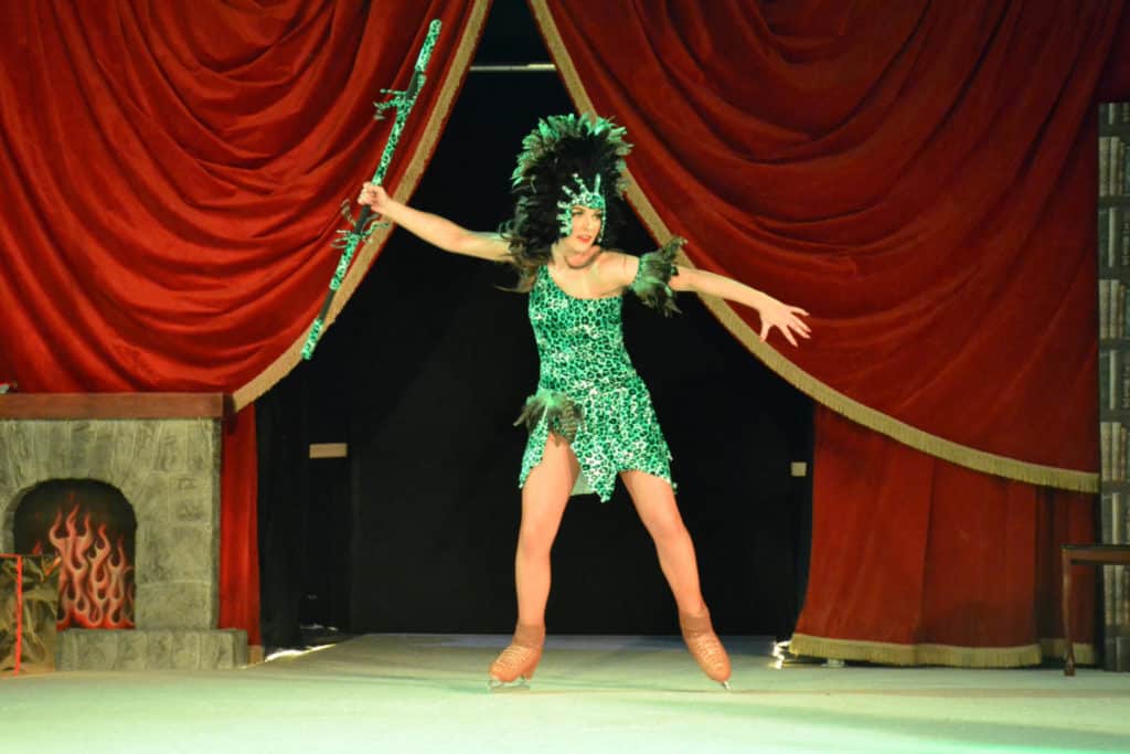 Ice skater in African costume holding spear