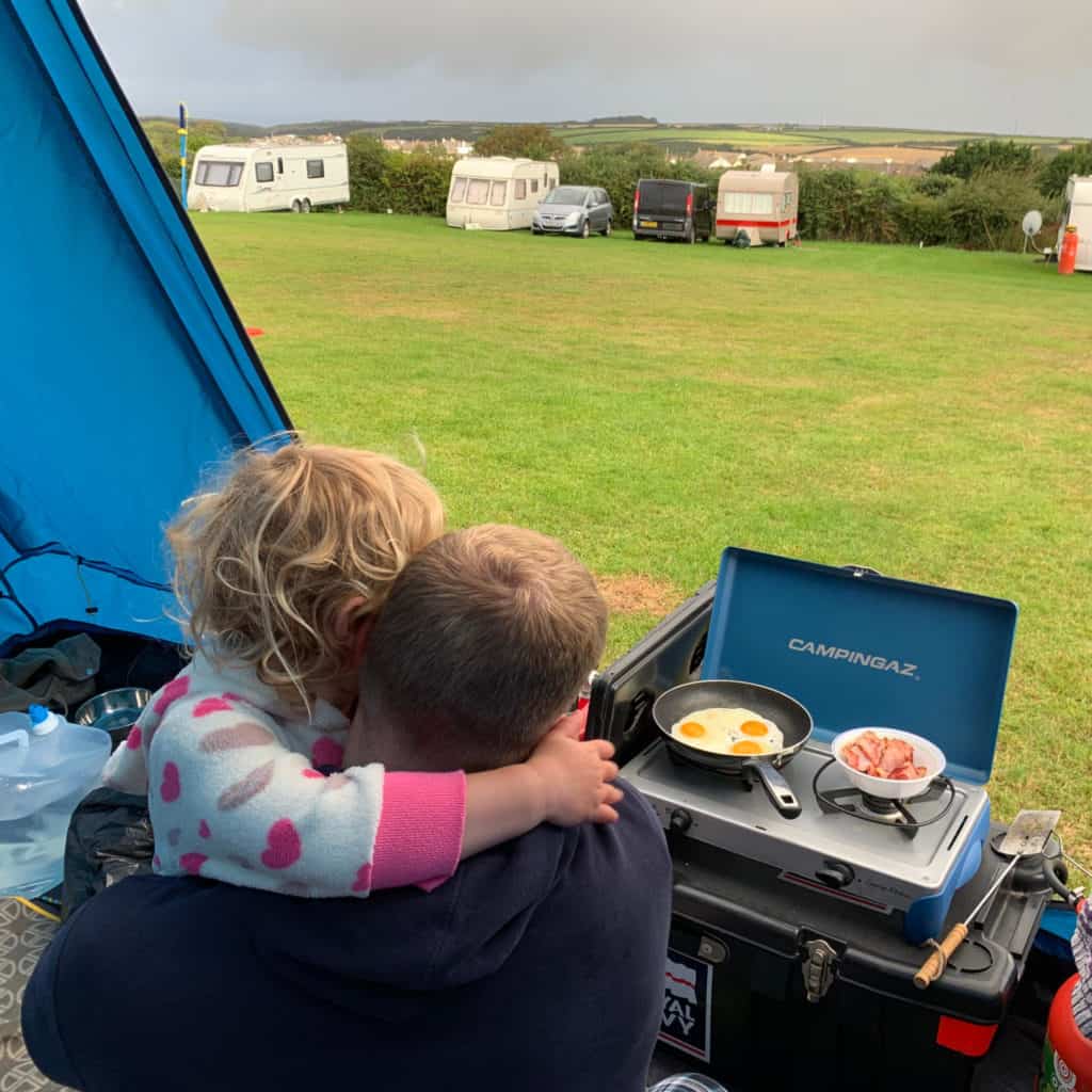 Mr Tin Box and Baby cooking breakfast while camping