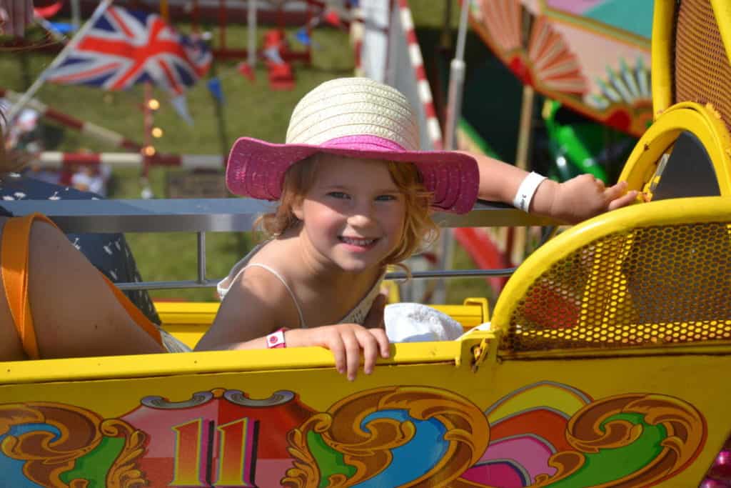 Tin Bx Baby on big wheel in fairground at festival
