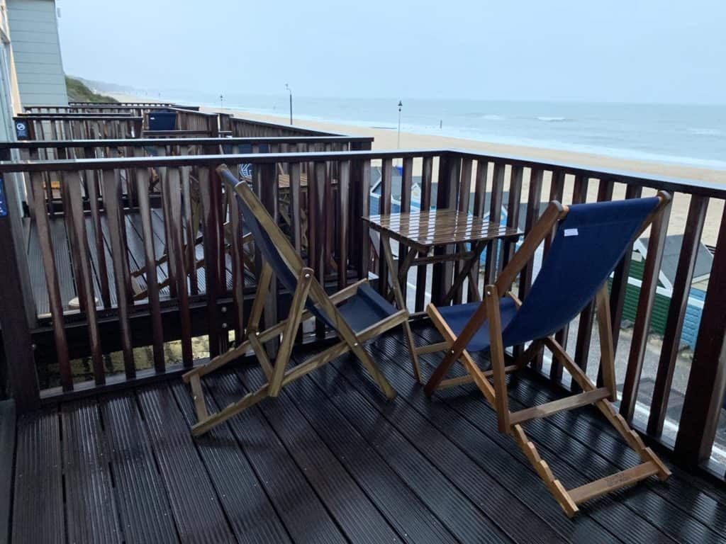 Deck chairs and table on balcony overlooking Boscombe Beach