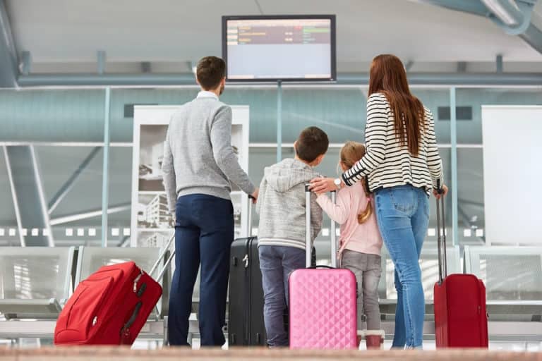 Family looking at airport departure board