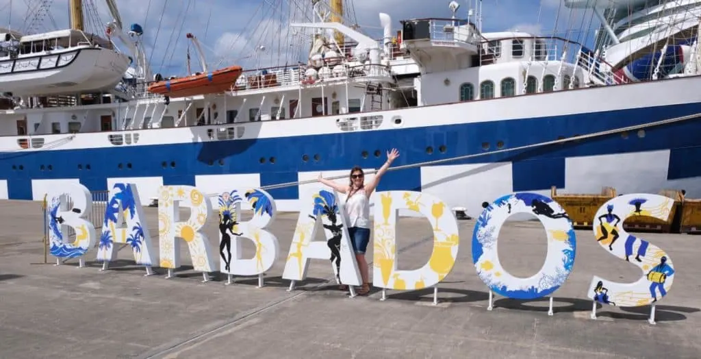 Tin Box Traveller stood with large Barbados sign