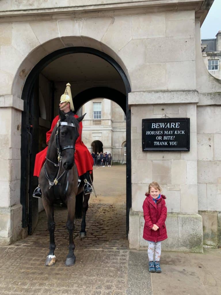 Baby standing next to horse guard box on Whitehall in London